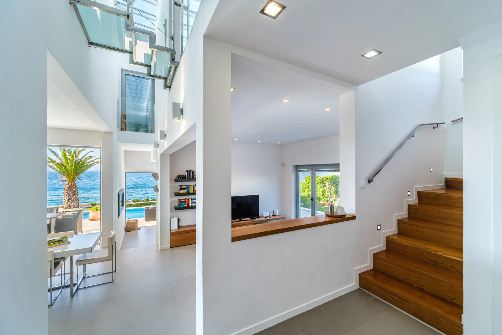 Bright sea-facing interior and timber staircase inside a private island residence