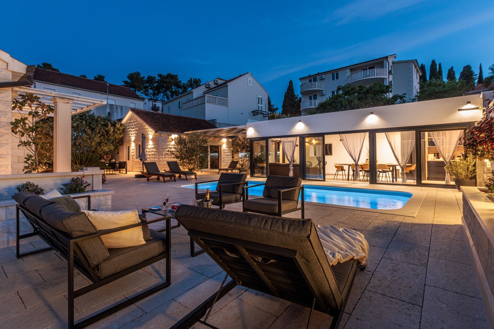 Illuminated stone courtyard and pool at a private harbour residence on Brač